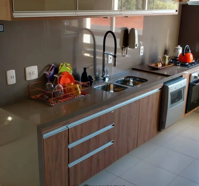 Cozinha com bancada escura e marcenaria amadeirada